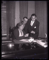 Minnie Kennedy signs a document with Guy Edward Hudson and Barney Bernard, United States, circa 1931-1932