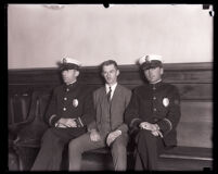 Man seated between 2 police officers in the courthouse during Asa Keyes trial, Los Angeles, 1929