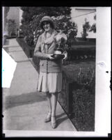 Actress Mary Brian holding a trophy award in the shape of a globe, Los Angeles, 1920s