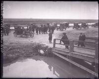 Crowd with their cars on a marshy bank, awaiting killer Phil Alguin's aquatic arrival, Freeport, Texas, 1923