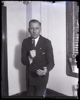 Buron Fitts, standing in his office, Los Angeles, 1920s 