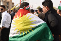 A man covering his back with a Kurdish flag