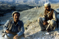 Two Mujahid Sits With Their Gun on The Top of Hill