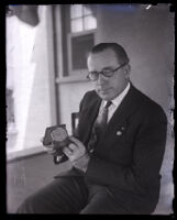 Captain Cato holds a clock as piece of evidence in the Leo Patrick Kelley murder case, Los Angeles, 1928