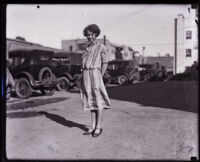 Nita Carson standing on a street smiling, Los Angeles, 1925