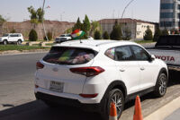 A car in Erbil with Barzani picture and Kurdistan flag