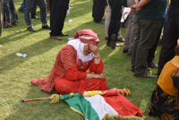 A woman sitting wearing Kurdish clothing