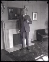 H. F. Alexander, president of Pacific Steamship Company, standing with pipe, Los Angeles, 1922-1930