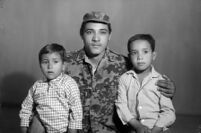 Studio portrait of a member of the Palestinian resistance with his children
