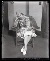 Eunice Pringle sitting in a wicker chair with eyes closed and head leaning on hand, Los Angeles, 1929