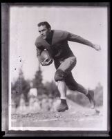 UCLA football team captain Joe Fleming running on a playing field, Los Angeles, circa 1928