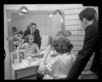 Actress Tallulah Bankhead seated at dressing room mirror with playwriter James Leo Herlihy, Calif., 1958