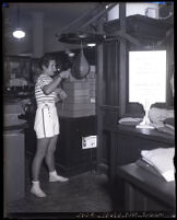 Boxing Champion Billie Bachelis demonstrates use of a punching bag at a May Company demonstration, Los Angeles, 1931