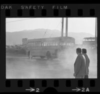 Los Angeles County Air Pollution patrolmen watch exhaust bellow from school bus, 1971