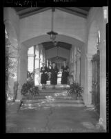 Josephine Andrews, Aureola Tibbot, and Mrs. Morris Knee walking down colonnade of Wilshire Methodist Church, Los Angeles, 1949