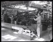 Assembly line workers putting first chassis online at Ford plant, Long Beach, 1930