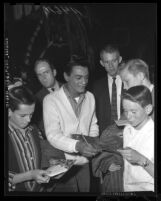 Johnny Mathis surrounded by autograph seekers in Los Angeles, Calif. in 1959