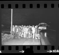 Jefferson Junior High School students waiting for bus in the dark [due to Energy Crisis] in San Gabriel, Calif., 1974