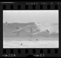 Surfers riding wave off Malibu, Calif., 1973