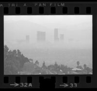 Downtown high-rise buildings surrounded by blanket smog in Los Angeles, Calif., 1973