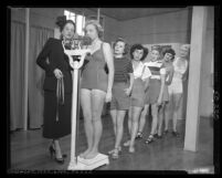 Women getting weighed at Models Academy and Finishing School with instructor, Joan Van Treel in Los Angeles, Calif., circa 1950