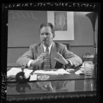 L. Ron Hubbard seated as desk, 1950