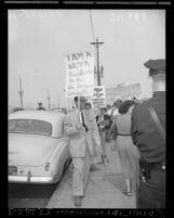 Picket with sign reading "I am a writer blacklisted by the Un-American Committee" outside committee hearing in Los Angeles, Calif., 1952