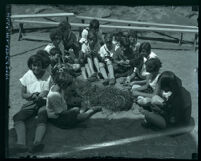 Girls sitting in semi-circle learning basket weaving at Griffith Park Girl's Camp, Los Angeles, 1924-1930