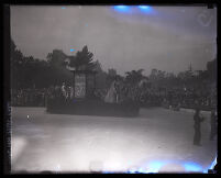 1928 Rose Parade spectators watching Sherman Institute's float depicting scenes of American Indians