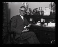 Chief criminal deputy sheriff, Harry Wright beside his desk with his gun and badge, Los Angeles, 1931