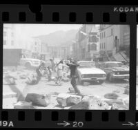 Actors dodging rubble during filming of motion picture "Earthquake" in Los Angeles, Calif., 1974