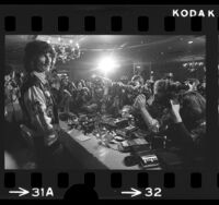 Musician George Harrison standing before crowd of photographers in Los Angeles, Calif., 1974