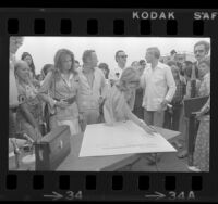 Joanne Woodward with other actors signing petition against oil drilling off the California coast in Santa Monica, Calif., 1974