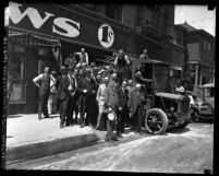 Group portrait of newspaper officials standing on curb out front of Los Angeles Daily News, 1923