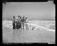 Five construction workers with water hose at Hansen Dam site, Calif., circa 1940
