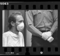 HIV positive Joseph Markowski wearing mask flanked by sheriff wearing latex gloves in court in Los Angeles, Calif., 1987