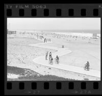 Cyclists riding along the bike path at Dockweiler State Beach, Calif., 1976