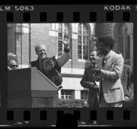 President Gerald Ford on podium with running back Ricky Bell during campaign stop at University of Southern California, 1976