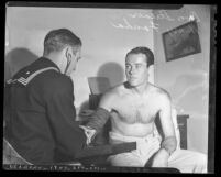 Don Strever taking actor Henry Fonda's blood pressure during medical examine for U.S. Navy, circa 1942