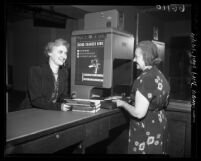 Los Angeles Public Library clerk using photo-charging machine, 1950