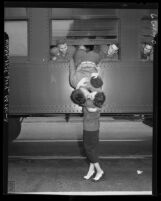 California National Guardsman hanging out window of train, kissing his wife good-bye, 1950