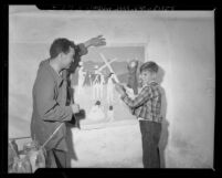 Jimmy Thornton gets instruction from artist John Bohrer while painting mural at San Fernando Mission, Calif., 1948