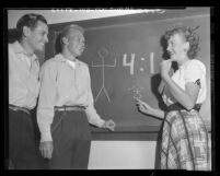 Shirley Mae Dyson illustrates on blackboard that there are four men for every girl at Glendale College, Calif., 1948