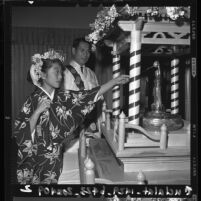 Larie Akashi pours sweat tea over Kanbutsu statue at a Hanamido ritual in Los Angeles, Calif.