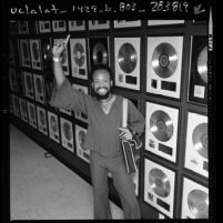Maurice White of Earth, Wind and Fire before wall of gold records, Calif., 1976