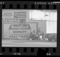 Men of "bottle gang" gathered outside liquor store in Los Angeles, Calif., 1977