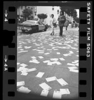 Spring Street littered with pages of 1977 calendar in New Year tradition, Los Angeles, Calif., 1977