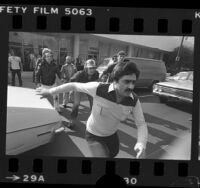 Iranian man running from group of men at clash between Pro-Iranian and Anti-Iranian demonstrators in Los Angeles, 1979