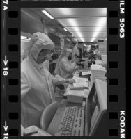 Three technicians in a clean room working with microprocessor chips in Los Angeles, Calif., 1980