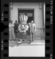 Entertainer Bob Hope escorting the 1984 Summer Olympics mascot, Sam the eagle down steps of Los Angeles City Hall, 1980